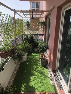 a small balcony with grass and potted plants