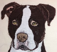 a close up of a dog's face on a piece of cloth with white and brown spots