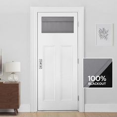 a white door with a black and gray sign next to it on a wall in a room