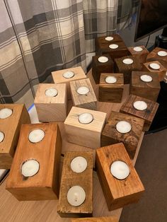 several wooden boxes with candles in them on a table