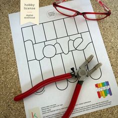 a pair of red scissors sitting on top of a piece of paper next to a pair of glasses