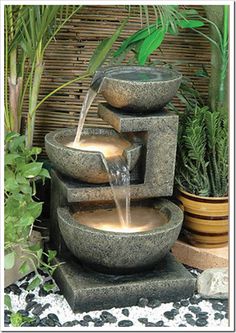 the fountain has three bowls on it and water is flowing from one bowl to another