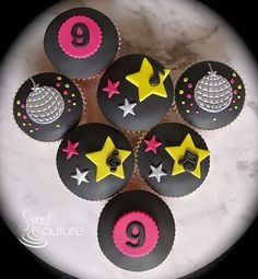 nine cupcakes decorated with black icing and yellow stars are arranged in a circle