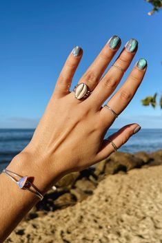 Image features a hand wearing a sea shell ring in front of the beach and the ocean. Beachy Jewelry, Jewelry Classic, Sea Glass Ring, Cowrie Shells, Love Jewelry, Shell Ring, Summer Love, Jewelry Studio, Glass Rings