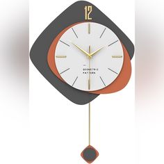 an orange and white clock hanging from the side of a wall in front of a white background