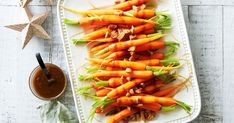 carrots and celery on a white platter with a brown sauce