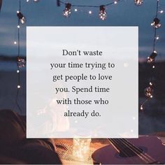 a guitar sitting on top of a table next to a string of lights and a quote that reads, don't waste your time trying to get people to love you