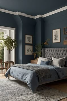 a bedroom with blue walls and gray bedding in the middle, along with pictures on the wall