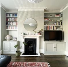 a living room filled with furniture and a fire place in front of a flat screen tv