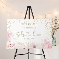 a welcome sign is displayed on a easel in front of a string of lights