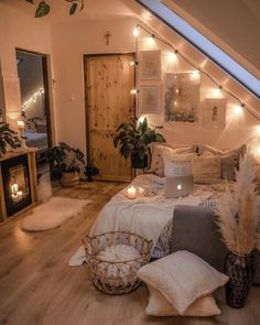 an attic bedroom decorated in neutral tones with lights on the ceiling and bedding, pillows and blankets