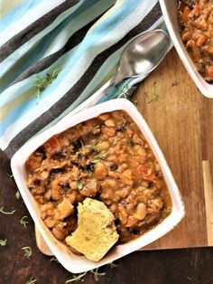 two bowls filled with food sitting on top of a wooden cutting board