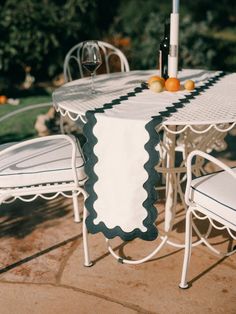 an outdoor table and chairs with wine bottle on it