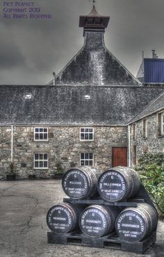 barrels stacked on top of each other in front of a building