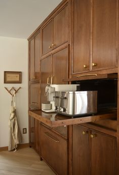 a kitchen with wooden cabinets and stainless steel appliance on the counter top in front of it