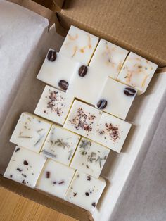 several squares of soap sitting on top of each other in a box with coffee beans