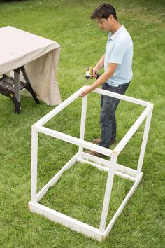 a man standing next to a table in the grass