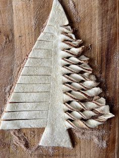 a wooden cutting board topped with a cut up christmas tree