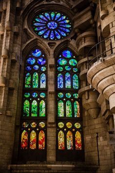 the large stained glass windows in this building are very colorful and intricately designed,