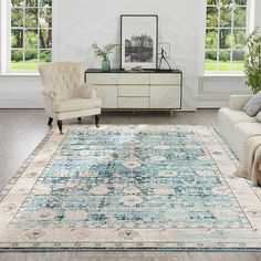 a living room with two couches and a rug on the floor in front of windows