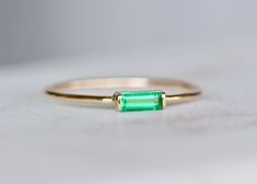 Beautiful green emerald is set in solid 14k gold. A solid gold band makes this suitable for everyday wear. Great as a gift to yourself or a loved one. *Made to Order. If you would prefer the use of an earth mined ruby please convo me. ◈ Gemstone : Emerald (Lab Created or Genuine, choose from dropdown) ◈ Ring Thickness: ~ 1 mm ◈ Gem Dimensions: 5x2mm ◈ Cut: Baguette ◈ Metal: 14K Solid Gold (18K also available - please convo me for a quote) ◈ Gold Color: Choose from dropdown Packaging : All produc Emerald Cut Green Stackable Rings In 14k Gold, Green Emerald Stackable Ring With Baguette Cut, Green Baguette Cut Stackable Emerald Ring, Dainty Green 14k Gold Stackable Rings, Everyday Minimalist Emerald Cut Ring, Everyday Emerald Ring In Yellow Gold, Green Emerald Ring For Everyday Wear, Everyday Minimalist Emerald Ring, Elegant Green Emerald Ring For Everyday