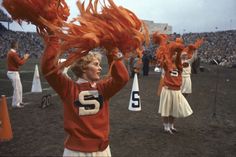 the cheerleaders are in orange and white outfits with their pom poms