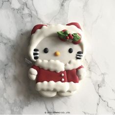 a hello kitty cookie sitting on top of a marble counter next to a white wall