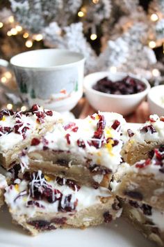 several pieces of cake sitting on top of a white plate next to a christmas tree