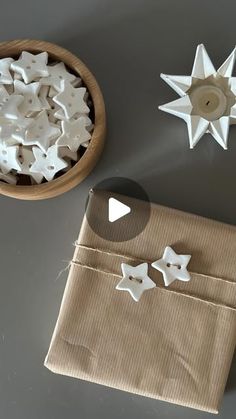 some white stars are sitting on a table next to a brown bag and a bowl