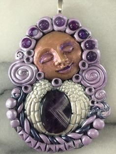 A Purple, Lavender, Beige and White Angel Wings Spiral Goddess Pendant / Medallion / Talisman with a Main Chevron Amethyst Gemstone and Eight Smaller Sphere Amethysts. Wear as a pendant or hang as a wall hanger Blessing in your home. Handmade. Mystical Purple Jewelry For Meditation, Spiritual Lavender Jewelry With Stones, Spiritual Lavender Stones Jewelry, Collectible Spiritual Purple Necklace, Purple Amethyst Symbolic Jewelry, Symbolic Purple Amethyst Jewelry, Symbolic Amethyst Purple Jewelry, Spiral Goddess, Goddess Moon