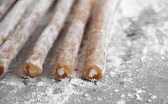 several pieces of food sitting on top of a metal table covered in powdered sugar