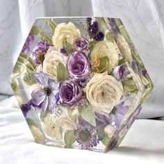 a glass vase filled with purple and white flowers