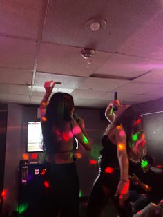 two women are dancing in a room with disco lights