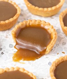 chocolate caramel tarts are sitting on a table