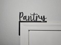 a metal sign that says pantry on top of a doorknob with the word pantry written in cursive font