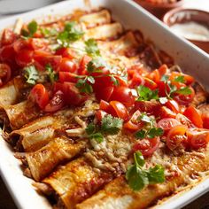 an enchilada dish with tomatoes and cilantro