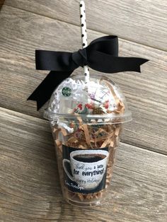 a coffee cup filled with marshmallows and other things on top of a wooden table