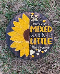 a sunflower painted on the side of a wooden sign