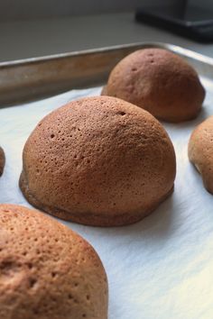 some brown buns are sitting on a baking sheet