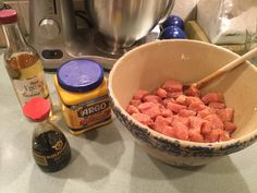 a bowl filled with meat sitting on top of a counter next to a blender