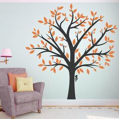 an orange and black tree wall decal in a child's room with a chair