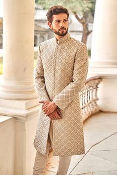 Beige sherwani featuring chikankari floral motif highlighted  with zardozi embroidery. Paired with churidar. Component: 2 Pattern: Embroidered Type Of Work: Zardozi Neckline: Mandarin Collar Sleeve Type: Straight Full Fabric: Chikankari, Silk Color: Beige Other Details:  Intricate floral motifs Zardozi highlights Front and side slit sherwani Note: The green bandhgala set worn by the model on the right is not for sale Occasion: Groom - Aza Fashions Chikankari Sherwani For Men, Marathi Wedding, Haldi Outfits, Jayanti Reddy