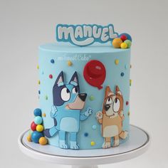 a blue cake decorated with cartoon characters on it's sides and the words manvel