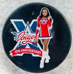 a pin with an image of a cheerleader in red and blue on the front