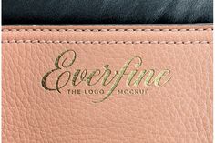 closeup of the logo on an empty pink leather bag with black linings and gold foiling