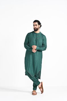 Bottle green criss cross jhaal embroidered on Modal silk with zari stitchline, pintuck and assymetrical hemline kurta. Paired with bottle green slim fit Pant Pajama. Color of the actual garment may vary due to lighting conditions during the shoot.
 

Size Chart For Men





	
	
					Men's Size Chart
		

		
		
						
				Size Chart For Men
				Custom Size Measurement Guide
			
			
				
				
				Custom Size Measurement Guide
1. Take your measurements at ease…don’t hold your breath!
2. Be a little Green Slub Silk Kurta With Dabka Work, Green Slub Silk Churidar For Transitional Season, Transitional Green Slub Silk Churidar, Green Cotton Silk Kurta With Zari Work, Green Zari Work Kurta In Cotton Silk, Green Cotton Silk Kurta With Chikankari Embroidery, Designer Chikankari Embroidery Kurta For Spring, Designer Spring Kurta With Chikankari Embroidery, Designer Green Kurta For Spring