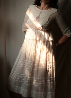 a woman in a white dress is posing for the camera with her hands on her hips