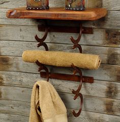 a wooden shelf with two towels on it and some shoes hanging from the hooks next to it