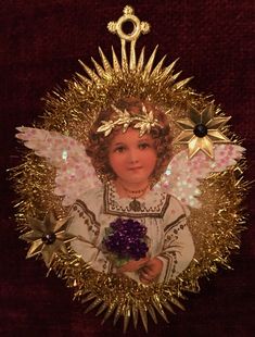 an angel ornament with gold tinsel and purple flowers in it's center