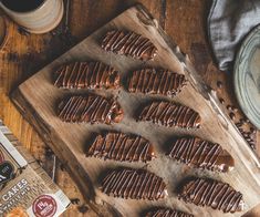 chocolate covered cookies on a cutting board next to a cup of coffee